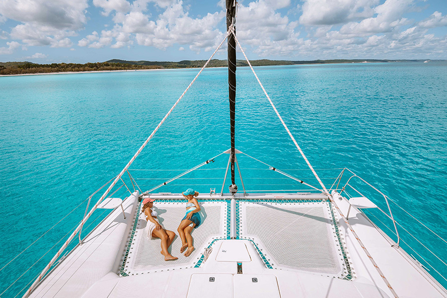 Two girls laying on front of yacht