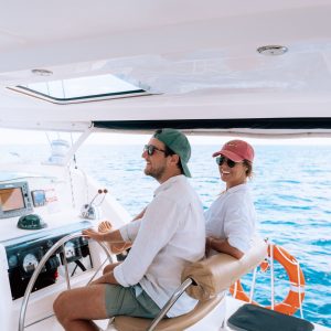 Two people at helm of a yacht charter