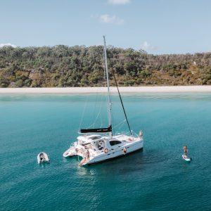 Yacht at anchor with person on paddleboard